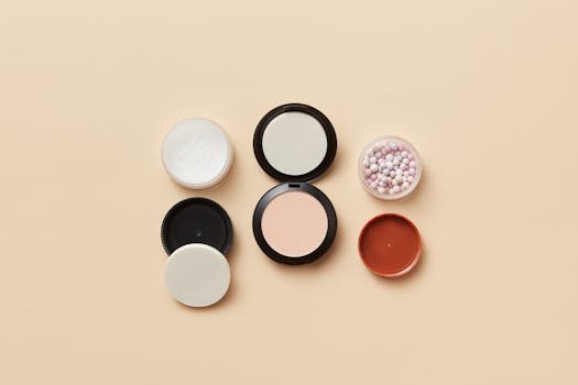 Cum să Alegi Bluze Elegante Plus Size pentru Birou 2 Flat lay of assorted makeup containers and powder balls on a beige surface, showcasing beauty essentials.